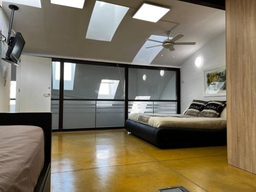 a bedroom with two beds and a ceiling fan at Espectacular Loft en pleno centro de Alcázar. in Alcazar de San Juan