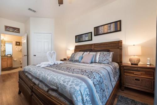 1 dormitorio con 1 cama grande y cabecero de madera en LUXURIOUS CONDO - JUST 2 MILES FROM DISNEY #404, en Orlando