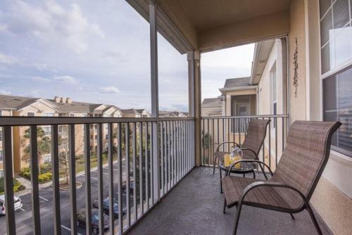 a balcony with two chairs and a view of a street at LUXURIOUS CONDO - JUST 2 MILES FROM DISNEY #404 in Orlando