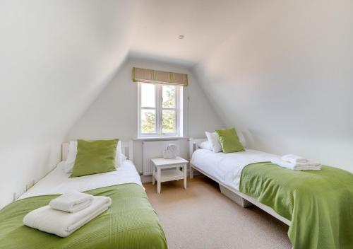 2 camas en una habitación con verde y blanco en 7 Sanctuary, en Thorpeness