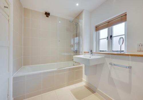 a bathroom with a tub and a sink and a bath tubermottermott at Kiln House in Snape