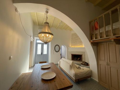 a living room with a wooden table and an archway at Theros - Traditional House in Psinthos in Psinthos