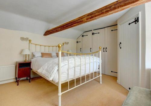 a bedroom with a bed with a white bed frame at Walnut Tree Cottage in Mildenhall