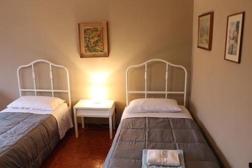 Zimmer mit 2 Betten und einem Tisch mit einer Lampe in der Unterkunft EasyRoom Schio in Schio