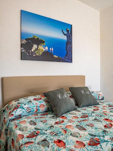 a bedroom with a bed with a picture on the wall at Casa Astra in Anacapri