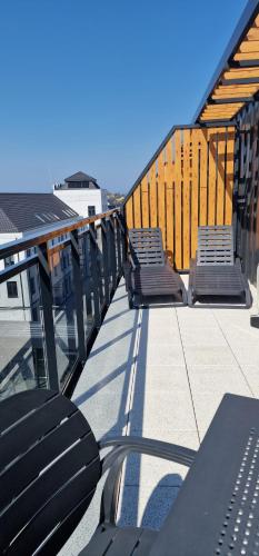 dwie ławki siedzące na dachu budynku w obiekcie Bel Mare apartament prywatny Milamare Parking gratis w mieście Międzyzdroje