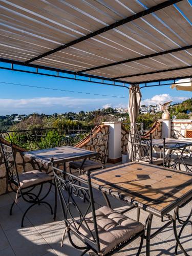a patio with tables and chairs on a balcony at Casa Astra in Anacapri