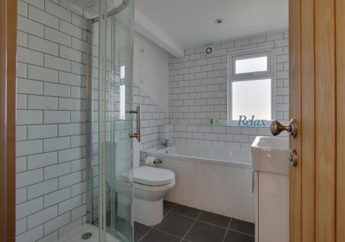 a bathroom with a toilet and a tub and a sink at Friday Place in Middleton