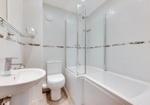 biała łazienka z toaletą i umywalką w obiekcie The Cartlodge w mieście Sudbury