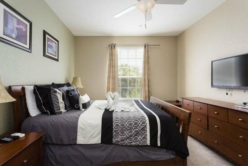 a bedroom with a bed and a flat screen tv at Fantastic Condo - 2 Miles from Disney Pool View Windsor Hills in Orlando