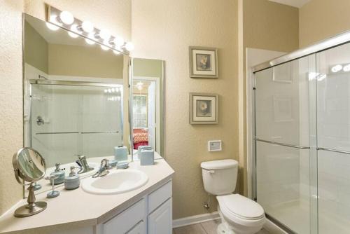 a bathroom with a toilet and a sink and a shower at Fantastic Condo - 2 Miles from Disney Pool View Windsor Hills in Orlando