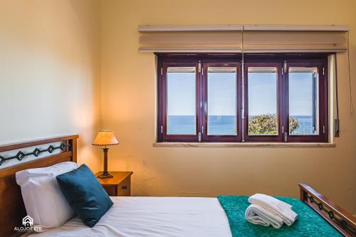 a bedroom with a bed with a view of the ocean at Casa à Beira Mar - Countryhouse with Ocean view in São Pedro da Cadeira