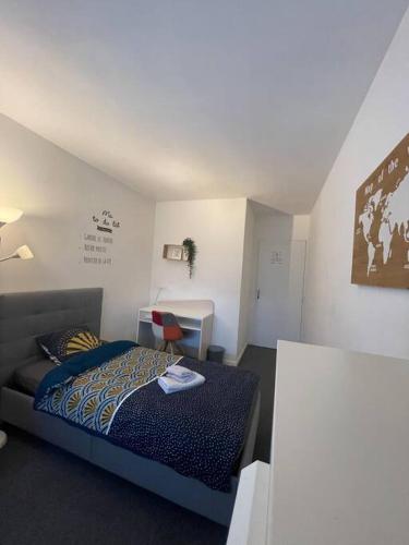 une petite chambre avec un lit et un bureau dans l'établissement APPARTEMENT COSY Balcon à 30min de PARIS, à Cergy