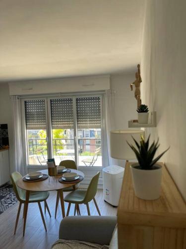 un salon avec une table et des chaises dans l'établissement APPARTEMENT COSY Balcon à 30min de PARIS, à Cergy