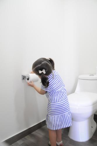 Een klein meisje houdt een rol toiletpapier vast. bij Hotel Refugio in San Juan de los Lagos