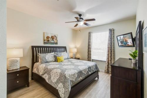 - une chambre avec un lit et un ventilateur de plafond dans l'établissement GROUND FLOOR OVERSIZED CONDO - NEXT TO DISNEY! #104, à Orlando