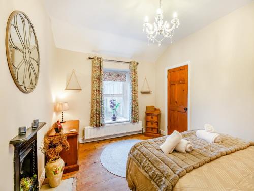 a bedroom with a bed and a chandelier at Mill Cottage in Clitheroe