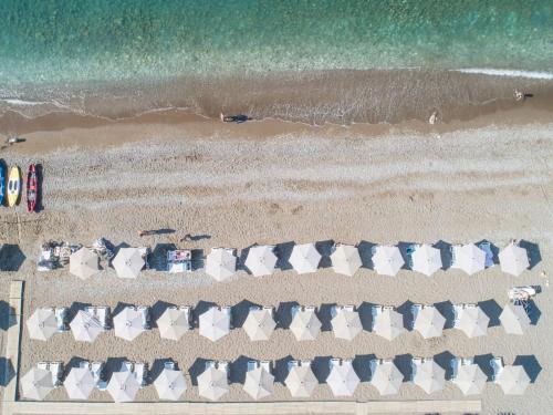 an overhead view of a beach with chairs and the ocean at PEARL BEACH RESORT - Hills & Villas in Čanj