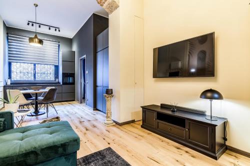 - un salon avec un canapé et une télévision dans l'établissement Bligny Studio 4PAX WIFI Bocconi District, à Milan