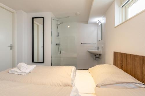 a bathroom with two beds and a shower and a sink at Strandvilla 30 Renesse in Renesse