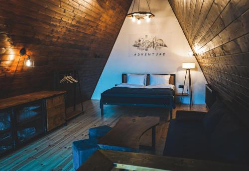 a bedroom with a bed and a couch in a room at Cottage GarShemo Kazbegi in Kazbegi