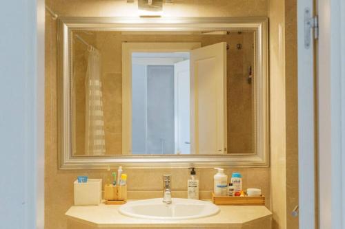 un lavandino da bagno con un grande specchio sopra di Chalet con Impresionantes vistas en Conil a Conil de la Frontera