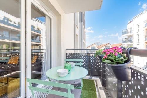 a balcony with a table and a pot of flowers at The Sunshine- Appart cosy proche Paris-Disney avec Parking privé dans résidence in Meaux