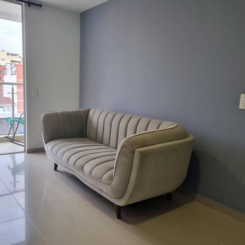 a couch sitting in a living room next to a wall at Soniella apto - WAIWA HOST in Bucaramanga