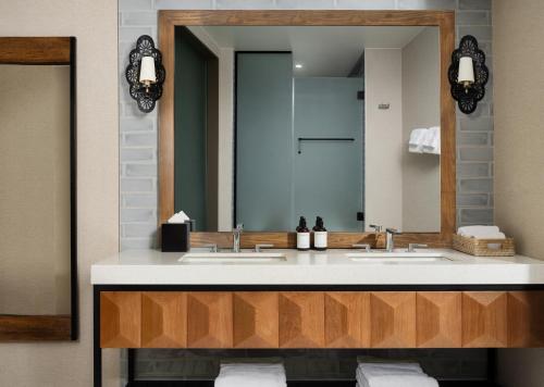 a bathroom with two sinks and a large mirror at Plaza San Antonio Hotel & Spa, Autograph Collection in San Antonio