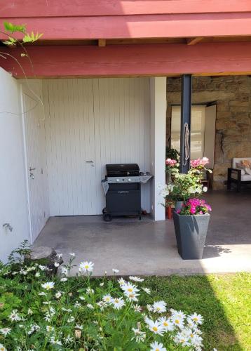a patio with a grill and flowers in a yard at Alijó Douro House in Alijó