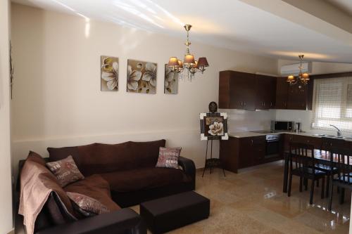 a living room with a couch and a kitchen at Indigo luxury apartments in Olympiaki Akti