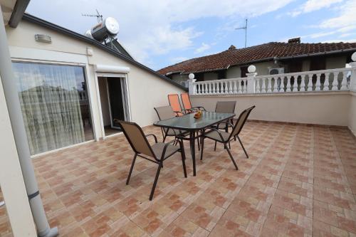 een patio met een tafel en stoelen op een balkon bij Indigo luxury apartments in Olympiakí Aktí