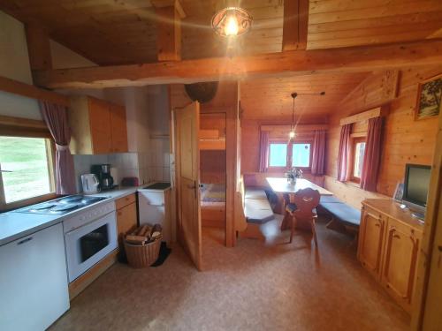 eine Küche und ein Esszimmer eines Blockhauses in der Unterkunft Weiherhütte Ried in Ried im Oberinntal