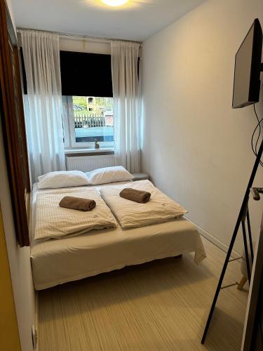 a bedroom with a bed with a window and a television at Pensjonat Jagoda B&B in Międzyzdroje