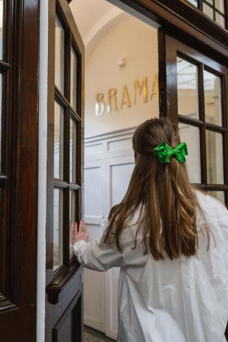 a woman is looking into a glass door at Brama in Bromley
