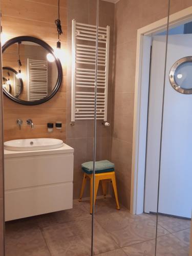 łazienka z umywalką, lustrem i stołkiem w obiekcie Port Mieszczański parking gratis we Wrocławiu