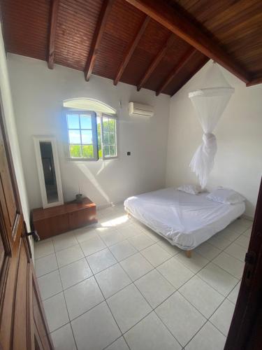 a bedroom with a bed and a window at Guadeloupe Guesthouse in Port-Louis