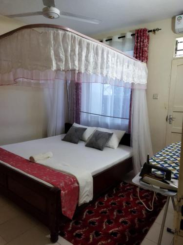 a bedroom with a bed with a canopy at Ocean Home, Nyali Mombasa in Mombasa