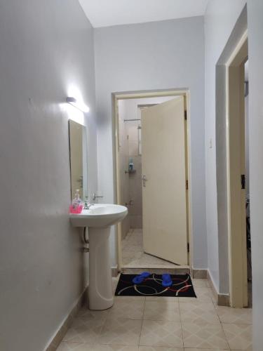 a white bathroom with a sink and a mirror at Ocean Home, Nyali Mombasa in Mombasa