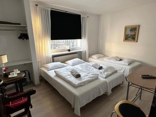 two beds in a room with a window at Pensjonat Jagoda B&B in Międzyzdroje