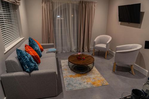 a living room with a couch and a table and chairs at Le Pommier in Castel