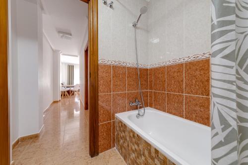 ein Bad mit einer Badewanne in einem Zimmer in der Unterkunft Penthouse CORBETA SUN in Torrevieja