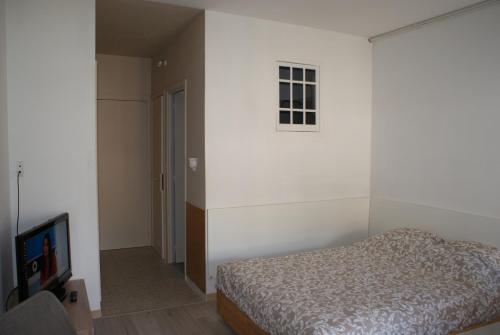 1 dormitorio con 1 cama y TV de pantalla plana en Studio Soleil Vernet, en Vernet-les-Bains