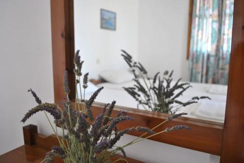 a bedroom with a mirror and a table with flowers at Antigoni Apartments 'Lavender Room' in Milatos