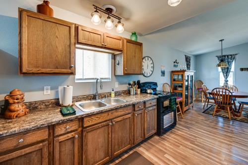 a kitchen with wooden cabinets and a dining room at Kingman Vacation Rental with Private Yard and Fire Pit in Kingman