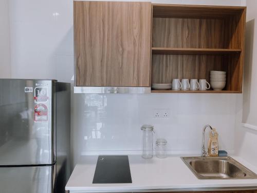 a kitchen with a refrigerator and a sink at Skydeck with KL City View Cozy 2 Bedroom in KL in Kuala Lumpur