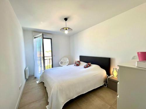 une chambre avec un lit blanc et une fenêtre dans l'établissement Appartement Standing avec Terrasse Vue Étang, 2 chambres et WIFI - Mèze - FR-1-604-37, à Mèze