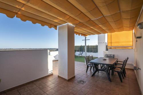 a dining room with a table and chairs on a patio at ÁTICO ATALAYA Parking privado gratis in Ayamonte