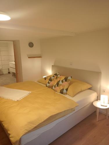 a bedroom with a large bed with yellow sheets and pillows at Stübchen in Nonnweiler