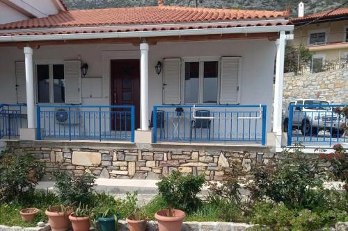 a house with blue railing and a stone wall at Εξοχική κατοικία Αnna's house 